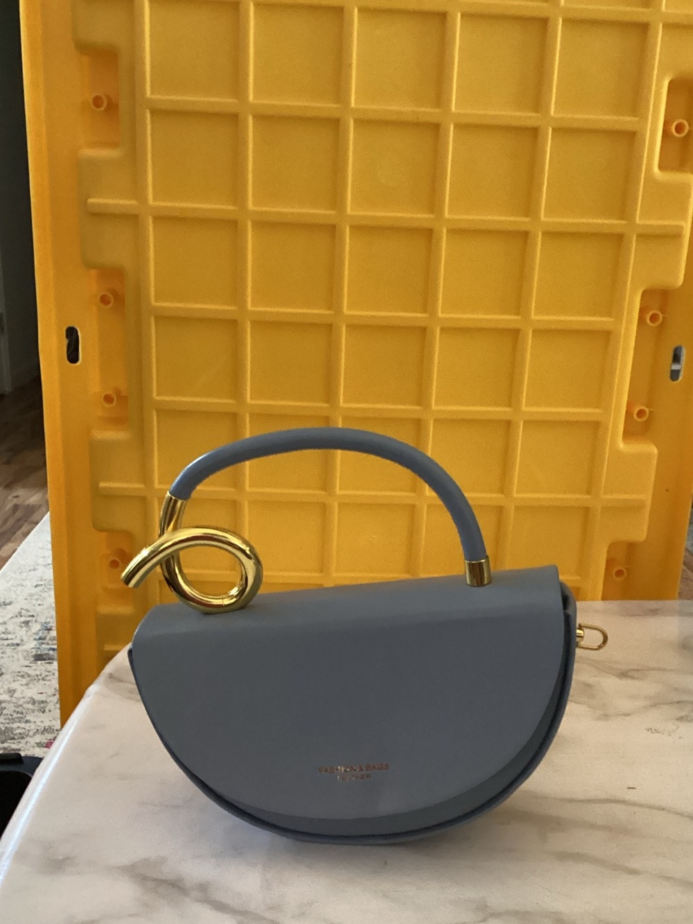 periwinkle blue half-moon top-handle bag with gold hardware